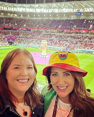 Jo with a friend inside a stadium 